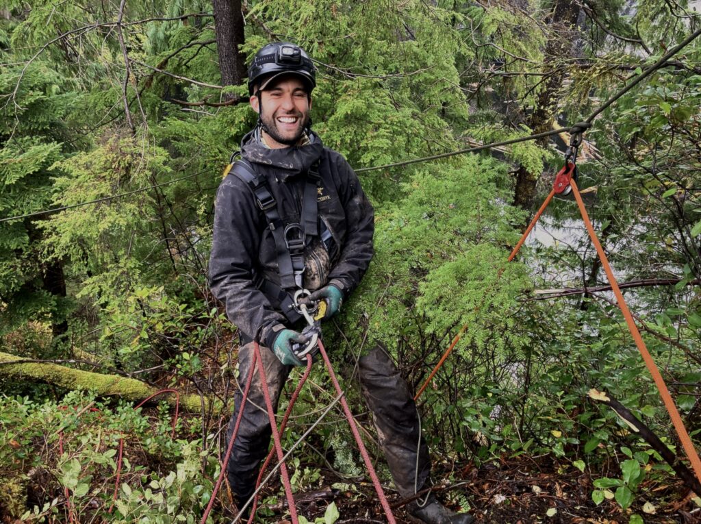 Rope access technician working in forest terrain